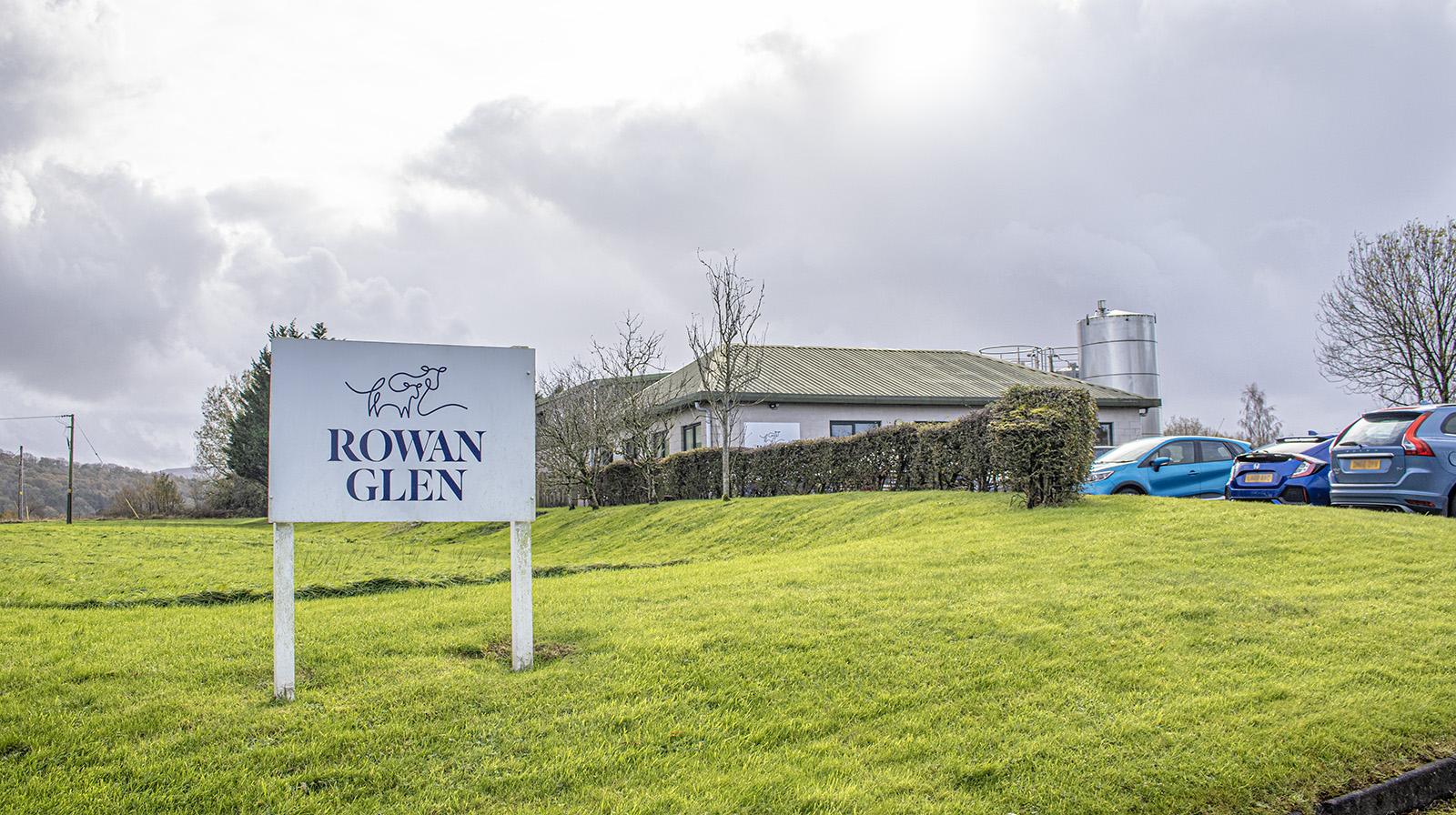Sign with Rowan Glen logo in front of their dairy factory in the Dumfries & Galloway countryside.